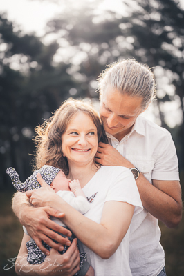 Glückliches Paar mit Baby im Arm in der Natur - Familienfotograf Brüggen Stephan Sohn